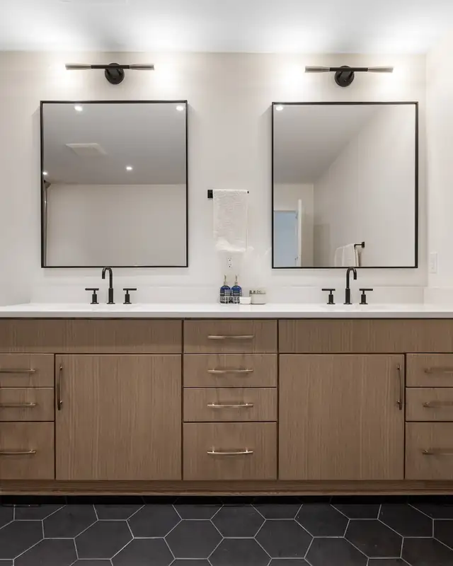 Waukesha, WI bathroom remodel with wood double vanity, white quartz top, black mirrors and black hexagon floor tile