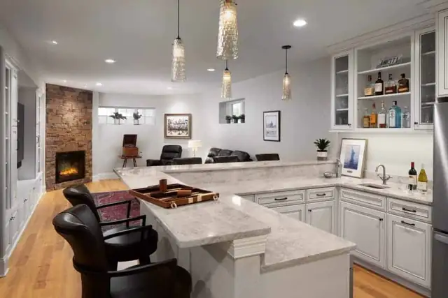Hartland, WI basement remodel with wet bar, quartz peninsula, glass-front cabinets and brick fireplace
