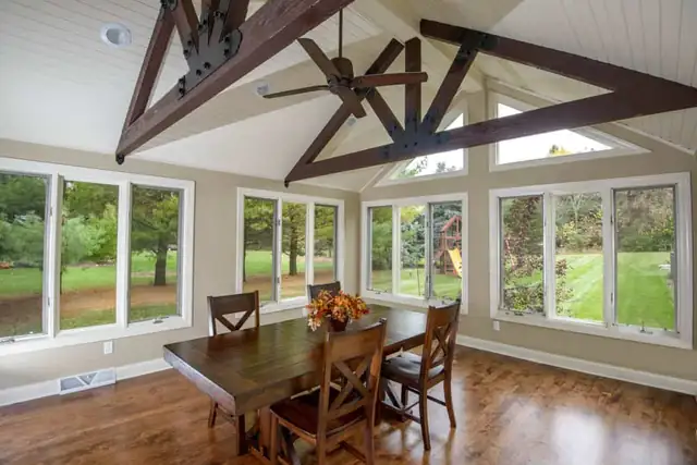 Brookfield, WI home addition with vaulted ceiling, dark timber trusses, wide windows and wood floor dining area