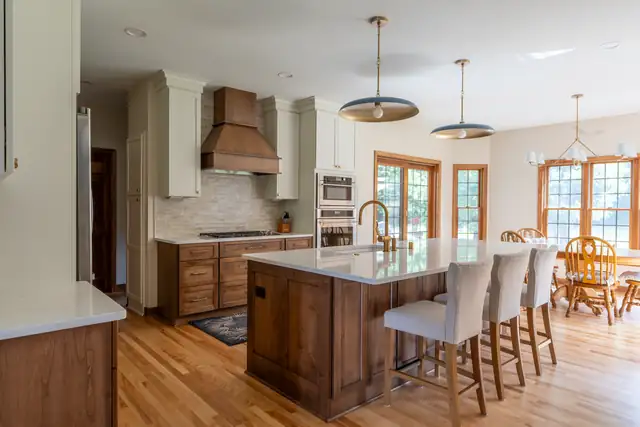 Sussex, WI kitchen remodel with walnut island seating four, copper hood, wall ovens and French doors to the yard