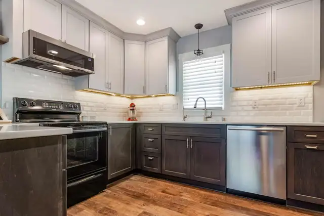 Waukesha kitchen remodel with gray upper cabinets, dark lower cabinets, white subway tile and under-cabinet lighting